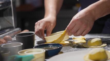 A person is making food on a table with various bowls and cups. Scene is casual and relaxed, as the person is focused on preparing the food
