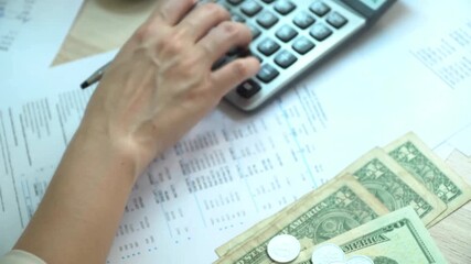 Calculating finances with calculator and currency for budgeting and financial planning on a wooden desk creating a dynamic business environment - Powered by Adobe