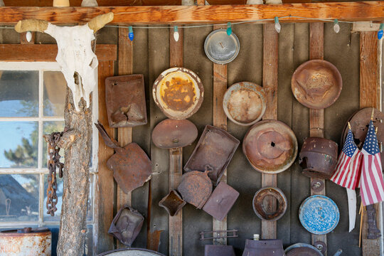 Goldpoint, Nevada, USA. Old rusted mining and cookware pans hanging on and old abandoned wooden building