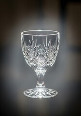 Elegant stemmed glass with intricate starburst pattern on a dark surface