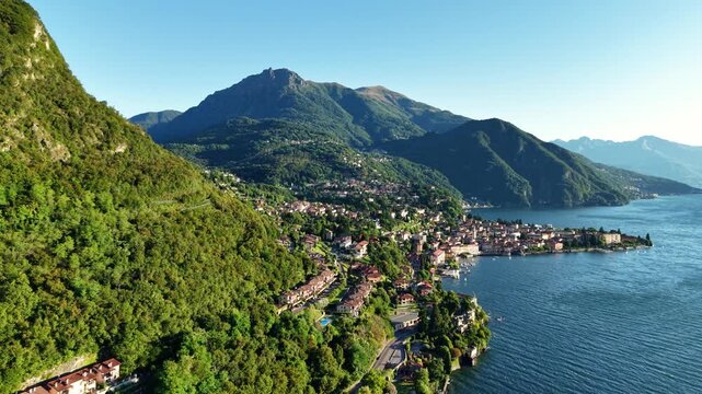 serene mountain scenery, aerial shot showcasing tranquil waterside hamlet surrounded by peaks