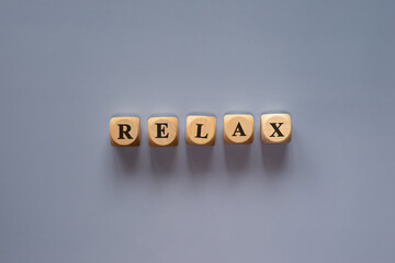 Letter cubes forming the word “Relax” on a bright background, symbol of calmness and relaxation