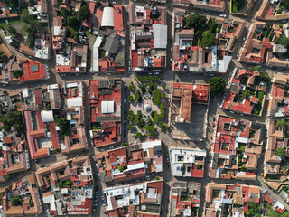 Aerial view of red-tiled roofs contrasting with the verdant plaza, capturing the essence of the town from above, Mascota, Jalisco, Mexico.