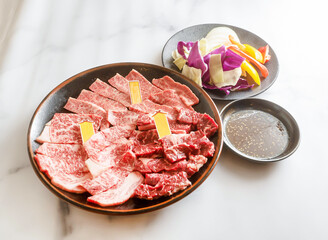 Enjoy a delightful Korean BBQ experience with this premium selection of raw beef, served with fresh vegetables and savory dipping sauce. Ready for the grill!