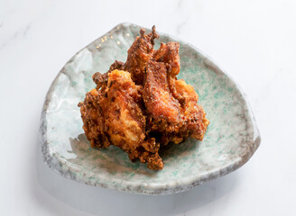 Tempting crispy fried chicken wings presented on a stylish plate. Perfect for menus or blogs, promising a delicious culinary experience!