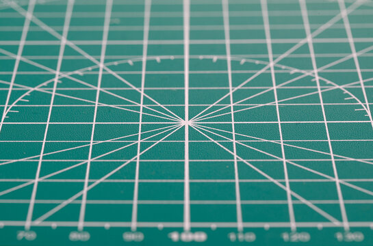Green cutting mat surface with grid lines for precision - Powered by Adobe