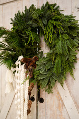 Natural Christmas Wreath With Pine Branches and Cones on Rustic Wooden Door