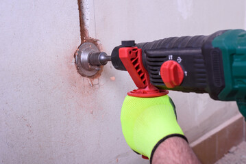 Contractor with hammer drill doing hole for socket