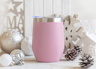 Blank pink Stainless Steel wine tumbler near Christmas baubles and decor on table, mockup