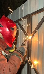 A male welder welds metal. Sparks, industry