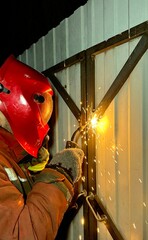 A male welder welds metal. Sparks, industry