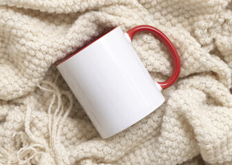 White accented coffee mug with red handle on beige plaid top view, boho mockup