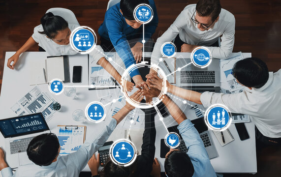 A diverse group of professionals collaborates in a modern office, showcasing team unity and growth through digital icons representing innovation and strategic alignment. Amity