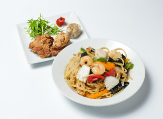 Savor scrumptious stir-fried noodles with succulent shrimp, crisp veggies, paired with golden fried chicken and delightful dumplings, perfect for any meal.