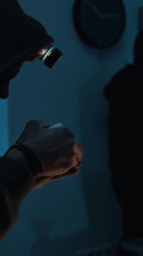 Vertical shot of Young thief catching and opening ring box tossed by his accomplice after taking it from office cabinet during burglary