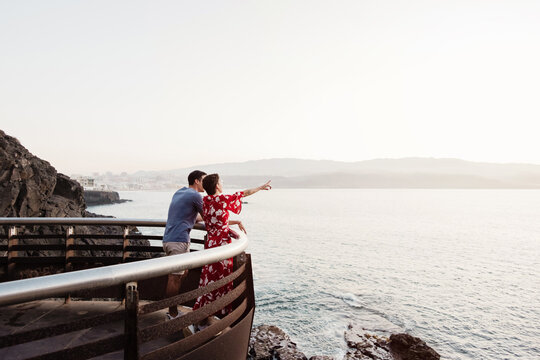 Couple watching ocean view from coastal viewpoint on holiday - Powered by Adobe