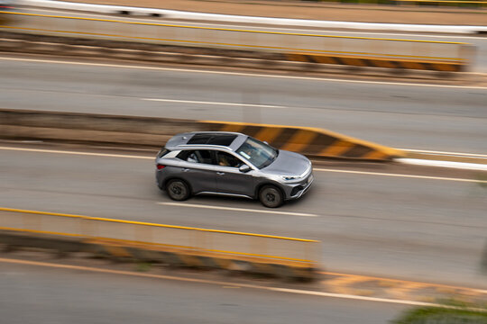 Silver BYD Yuan Plus side view, Electric SUV driving on highway