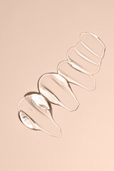 Glycerin gel texture. Transparent serum drop on beige background. Liquid gel moisturizer with bubbles macro