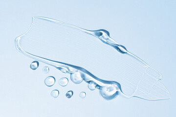 Cosmetic gel or beauty jelly serum texture background. Transparent skin care collagen product backdrop. Antibacterial sanitizer or liquid water moisture toner smudged smear, blue background