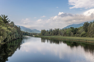 Obraz premium Serene nature landscape in Lake Placid, NY of the Ausable River and the Adirondack Mountains with blue skies.