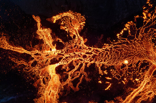 Aerial view of fiery rivers of molten lava snaking through the dark earth near Litli-Hrutur Mountain, Grindavik, Grindav&iacute;kurbaer, Iceland.