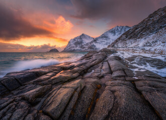Dramatic winter seascape on the Lofoten Islands in Norway with waves crashing over coastal rocks...