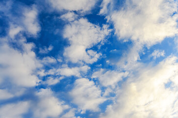 The bright blue sky is filled with puffy white clouds, creating a stunning and serene atmosphere