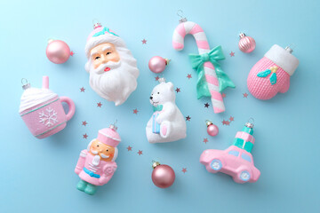 Obraz premium Collection of pink and white Christmas ornaments on pastel blue table. Flat lay, top view.