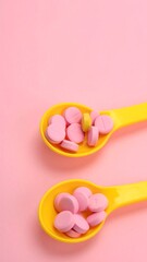 Fototapeta premium Pink and yellow pills are neatly arranged in yellow spoons on pink