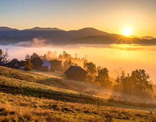 Sunrise brightens a foggy village in a peaceful rural landscape with golden morning light