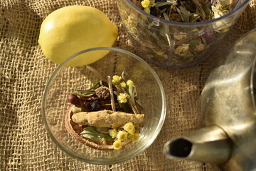 Herbs and spices  and turmeric root in a glass bowl on a burlap background