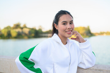 Fototapeta premium Young Asian Woman in Sporty Casual Outfit Outdoors in Lake Garden