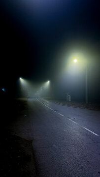 Misty nocturnal road whispers eerie tales, urban solitude, lost stories of Samhain wanderers, liminal space captured in gloom