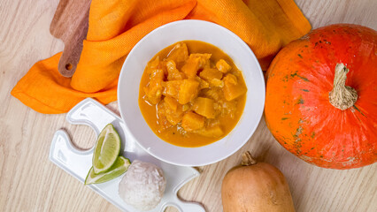 Aromatic pumpkin curry with zesty lime, autumnal indulgence, cozy Thai flavors, vibrant harvest feast, paired with sticky rice