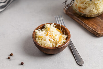 Sauerkraut with carrots in a wooden bowl.