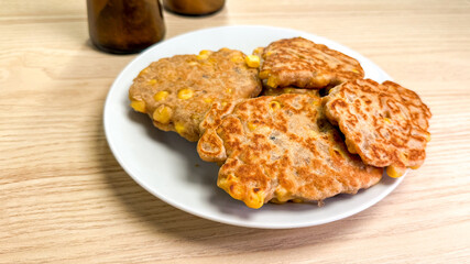 Crisp golden corn fritters on rustic plate, whispering autumn harvest tales, perfect for Thanksgiving or Sukkot festivities