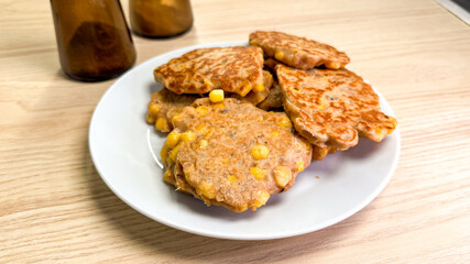 Golden corn fritters nestle on a plate, embracing rustic harvest vibes, ideal for Farm-to-Table Day indulgence