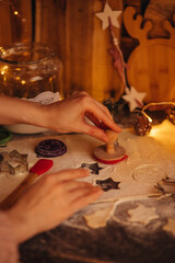 the hand of a woman baking Christmas cookies