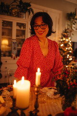 A woman is setting the table for Christmas dinner