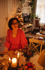 A woman is setting the table for Christmas dinner
