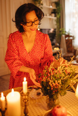 A woman is setting the table for Christmas dinner