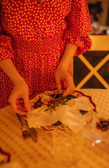 the hand of a woman setting the table for Christmas dinner