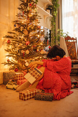 a woman with gifts under the Christmas tree