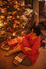 a woman with gifts under the Christmas tree