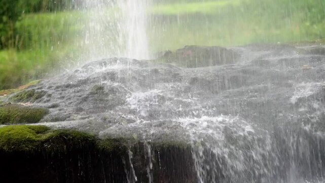 Water flowing over mossy rocks at Cascades during daytime in a Forest, nature's soothing symphony
