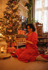 a woman with gifts under the Christmas tree