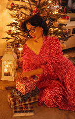 a woman with gifts under the Christmas tree