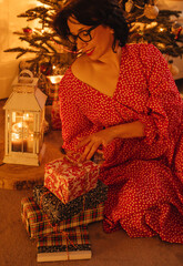 a woman with gifts under the Christmas tree