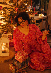 a woman with gifts under the Christmas tree