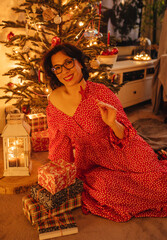a woman with gifts under the Christmas tree